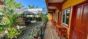 einen Balkon eines Hauses mit Bänken und Pflanzen in der Unterkunft OYO 1065 Summer Wind Pension in Puerto Princesa
