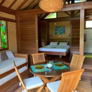 Cette chambre comprend un lit, une table et des chaises. dans l'établissement Oasis de Tendéa - Bali à Farino, à Farino