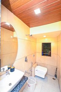 uma casa de banho com um WC, um lavatório e um espelho. em SK Villa em Āmbavna