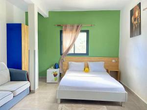 a bedroom with a white bed and a couch at AUBERGE DU NORD in Mitsamiouli