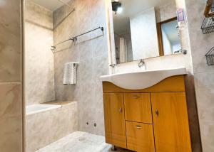 uma casa de banho com um lavatório, um espelho e uma banheira em Skol 439 Spacious and Refurbished Apartment with Sea Views em Marbella
