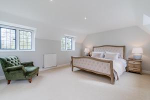 um quarto com uma cama e uma cadeira verde em Old Manse em Burford