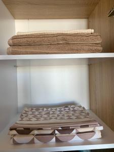 dwie półki z ręcznikami i ręcznikami w szafie w obiekcie Studio for rent w Kiszyniowie