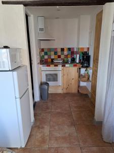 W kuchni znajduje się biała lodówka i kuchenka mikrofalowa. w obiekcie location Seillans var studio lavande 1e etage w mieście Seillans +2 zdjęcia