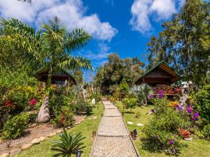 a garden with a pathway and flowers and houses at Oasis de Tendéa - Bali à Farino in Farino +54 photos