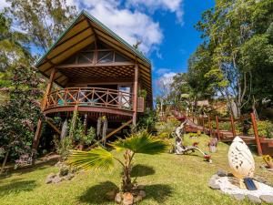 une cabane dans les arbres avec un balcon dans un jardin dans l'établissement Oasis de Tendéa - Bali à Farino, à Farino