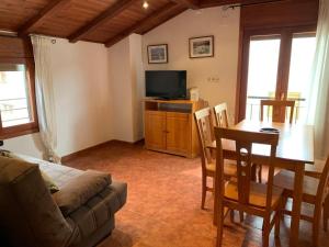 a living room with a couch and a table and a television at La Galera Barrios Altos in Guadalaviar