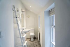 uma casa de banho com um WC branco e uma escada em Brooklyn Penthouse em Copenhague