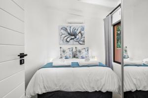 ein weißes Schlafzimmer mit einem Bett und einem Spiegel in der Unterkunft San Lameer Villa 1908 - 2 Bedroom Classic - 4 pax - San Lameer Rental Agency in Southbroom