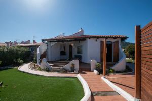 een klein huis met een patio en een tuin bij Villa Onda in Valledoria