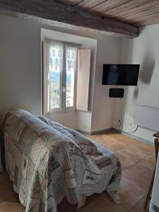 sypialnia z łóżkiem i telewizorem na ścianie w obiekcie location Seillans var studio lavande 1e etage w mieście Seillans