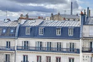 a building with a blue roof on top of it at Beautiful top-floor apartment with unobstructed view Paris 8th district ! in Paris