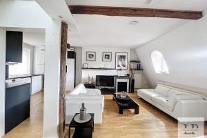 a living room with a white couch and a table at Beautiful top-floor apartment with unobstructed view Paris 8th district ! in Paris