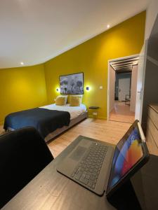 - une chambre avec un lit et un ordinateur portable sur une table dans l'établissement L Original - TravelHome - Free wifi - 6 travelers, à Villefranche-sur-Saône