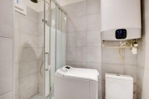 ein weißes Bad mit einem WC und einer Dusche in der Unterkunft Cosy 2P flat Parc des Princes Exelmans in Paris