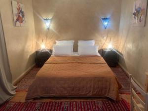 Un dormitorio con una cama con dos luces. en Hotel Riad Taroudant en Taroudant