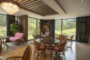 uma sala de jantar com mesas, cadeiras e janelas em PAZARCIK MOUNTAIN HOTEL em Trabzon