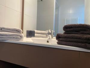 a bathroom with a sink and a mirror and towels at La Suite Griffon - Parking & Balcon in Toulouse