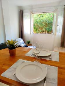 una mesa con un plato y una copa de vino en ella en Studio Plages Vélodrome by Villa Reiala en Marsella