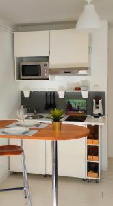 cocina con armarios blancos y mesa de madera en Studio Plages Vélodrome by Villa Reiala en Marsella