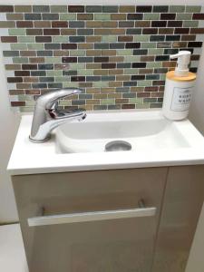 a sink in a bathroom with a brick wall at Studio Plages Vélodrome by Villa Reiala in Marseille