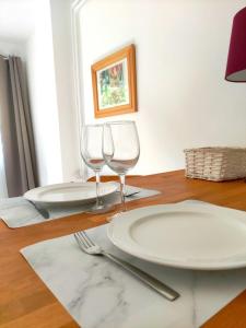 a table with a plate and two wine glasses at Studio Plages Vélodrome by Villa Reiala in Marseille