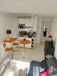 a living room with a table and a kitchen at Studio Plages Vélodrome by Villa Reiala in Marseille