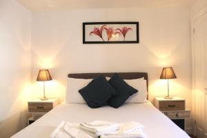 a bedroom with a white bed with two lamps at West Street Mews - Serviced Accommodation in Exeter