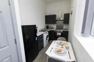 a small kitchen with a table with food on it at K Suites - Oak Court in Brierley Hill