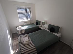 a small room with two beds and a window at K Suites - Harrogate Terrace 2 in Bradford