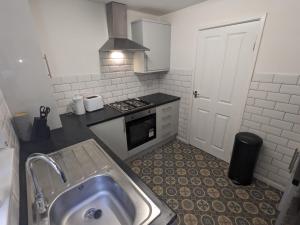 a kitchen with a sink and a stove at K Suites - Harrogate Terrace 2 in Bradford