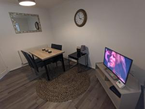 a living room with a table and a tv at K Suites - Harrogate Terrace 2 in Bradford