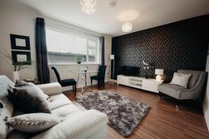 a living room with a white couch and a table at K Suites - Station Road in Hinckley