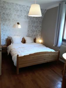 a bedroom with a large bed with white sheets at Gîte La Rose Jacuzzi Nordique in La Petite-Pierre