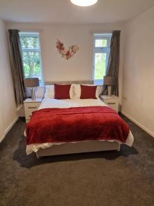 a bedroom with a large bed and two windows at K Suites - Harboro Grove in Sale