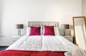 sypialnia z łóżkiem z różowymi poduszkami i lustrem w obiekcie K Suites - Harboro Grove w mieście Sale