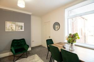 a dining room with a table and green chairs at K Suites - Carr Hill Road in Gateshead