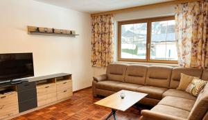 a living room with a couch and a television at Hallerhaus in Altenmarkt im Pongau