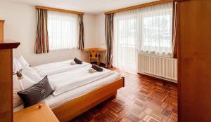 a bedroom with a large bed and two windows at Hallerhaus in Altenmarkt im Pongau +15 photos