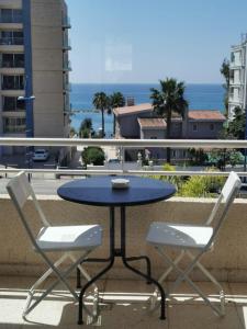 d'une table bleue et de 2 chaises blanches sur un balcon. dans l'établissement Nostalgia apts, à Limassol