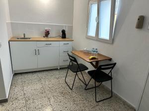 eine kleine Küche mit einem Tisch und 2 Stühlen in der Unterkunft Apartamento C san Jose de los Llanos in San Jose De Los Llanos