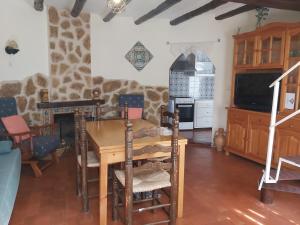 a living room with a wooden table and a kitchen at EL CASTELLET in Traiguera
