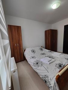 ein kleines Schlafzimmer mit einem Bett und Holzschränken in der Unterkunft Konak in Kragujevac