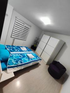 Schlafzimmer mit einem Bett mit blauer Decke in der Unterkunft Konak in Kragujevac