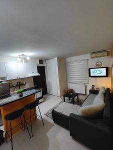 ein Wohnzimmer mit einem Sofa und eine Küche mit einem TV in der Unterkunft Konak in Kragujevac