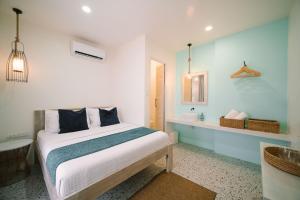 BIG WAVES BOUTIQUE HOTEL SIARGAO في جنرال لونا: غرفة نوم بسرير وحمام مع حوض