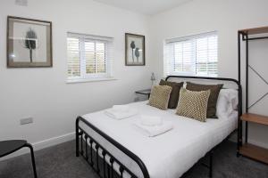 a bedroom with a bed with two white towels on it at Hartshorne House in Telford