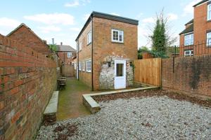 a brick house with a white door in a courtyard at Hartshorne House in Telford