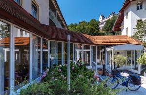 ein Gebäude mit einem gefliesten Dach mit Blumen und einem Fahrrad in der Unterkunft Burghotel Aschau in Aschau im Chiemgau