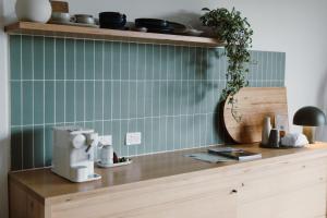 a kitchen with green tile on the wall at Ten Acres in Beechmont